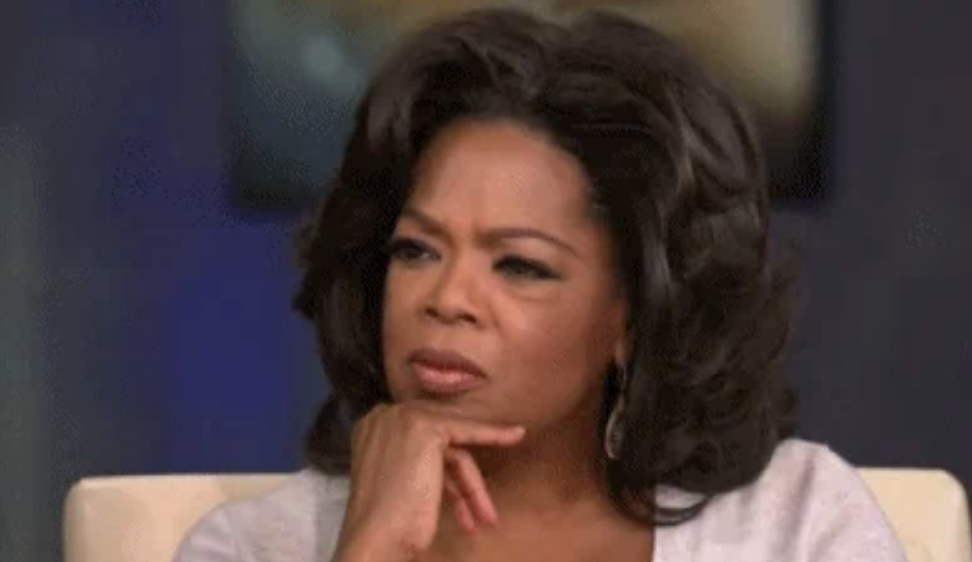 Oprah Winfrey with a thoughtful expression, resting her chin on her hand, during an interview