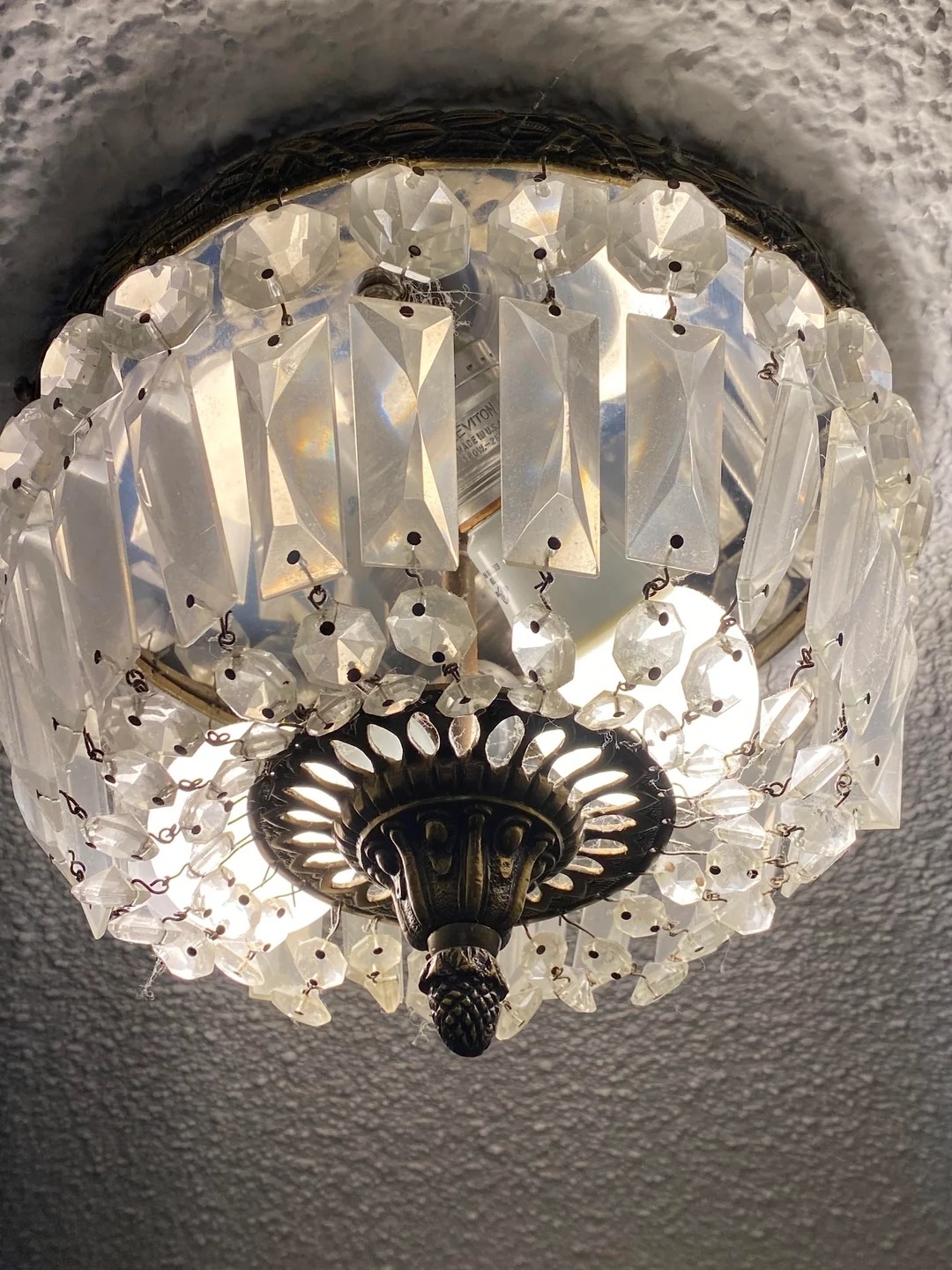 A close-up of a decorative ceiling light fixture adorned with hanging crystal-like ornaments creating a luxurious and elegant appearance