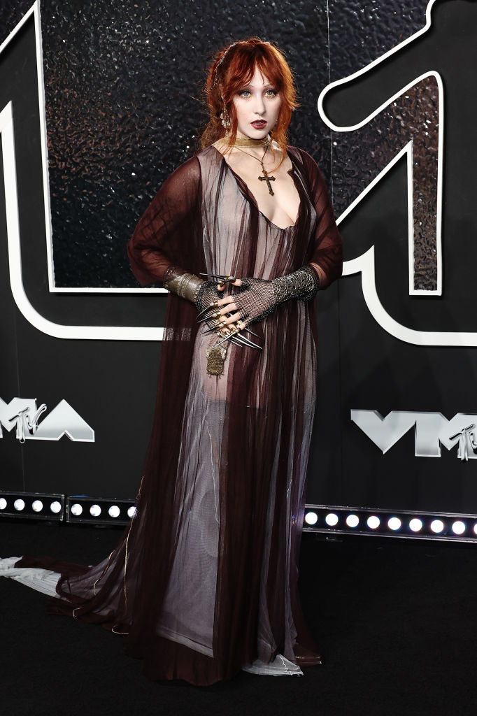 Chappell on the red carpet wearing a flowing, sheer gown with gothic accessories including gloves and a long necklace, at the VMAs