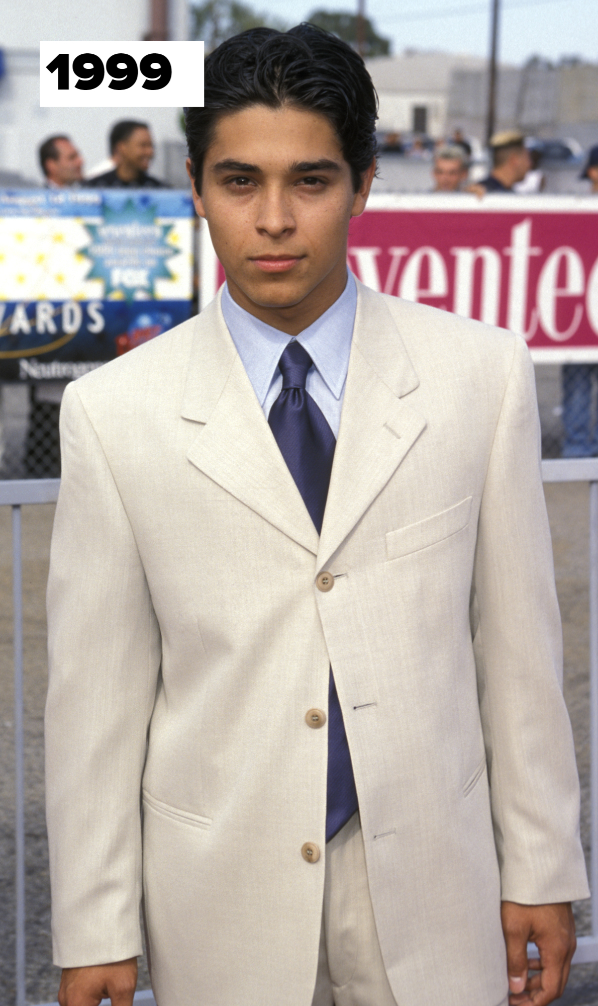 Wilmer Valderrama in a light-colored suit and blue tie at a 1999 event