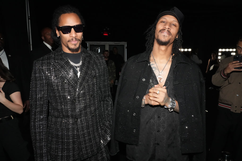 Les Twins in stylish, textured coats at a formal event