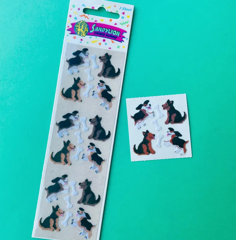 A Sandylion sticker set featuring a girl playing with a German Shepherd dog. There are several stickers on a larger sheet and a small separate sheet