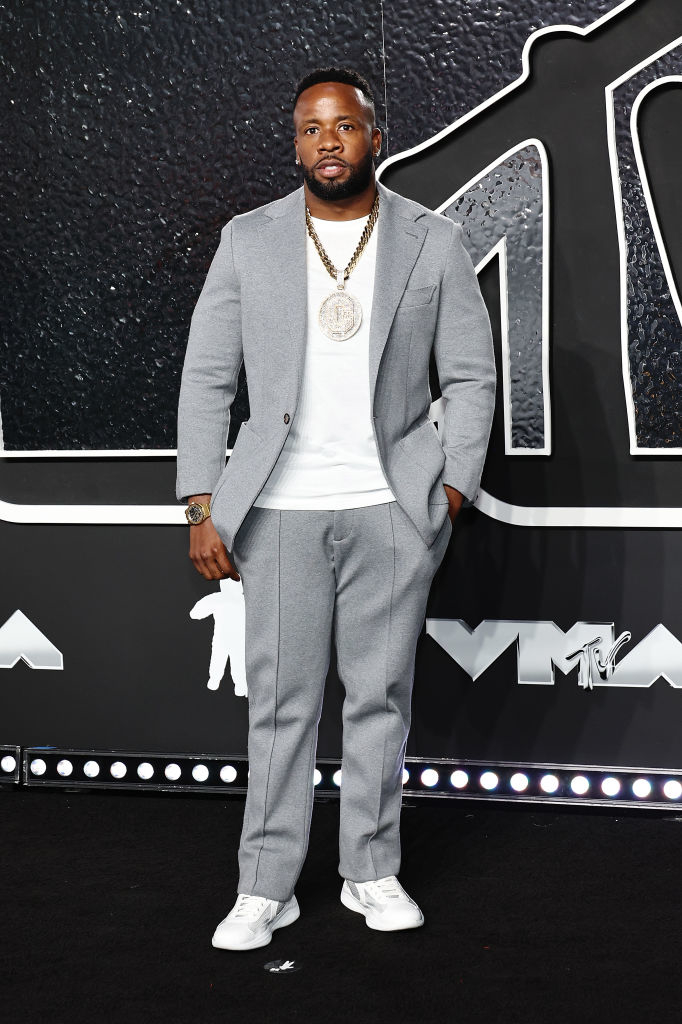 Yo Gotti wearing a light suit and sneakers