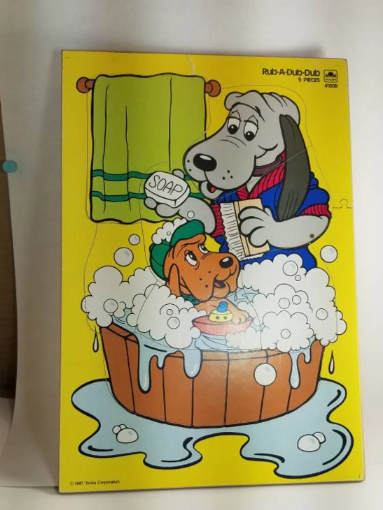 Illustration of Rub-A Dub-Dub with two cartoon dogs, one giving the other a bath in a wooden tub. One dog holds soap while the other sits in suds with a rubber ducky