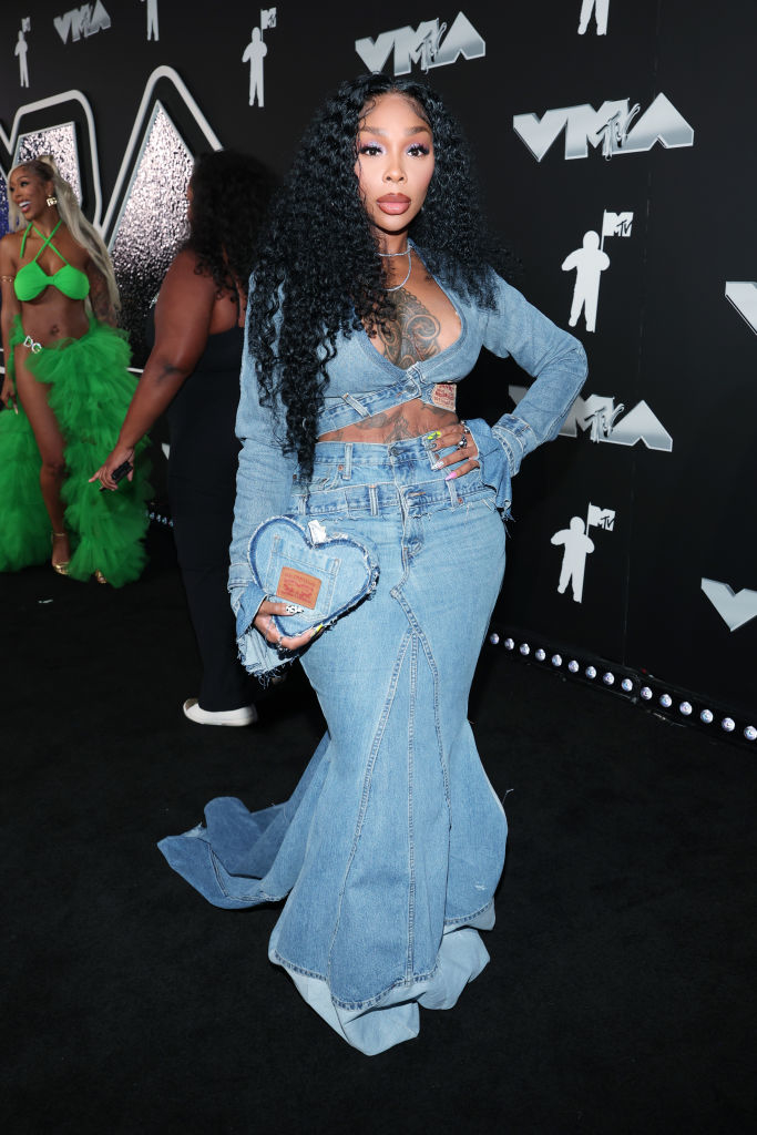Sierra at the VMAs in a denim outfit featuring a cropped jacket and a long skirt, holding a heart-shaped bag