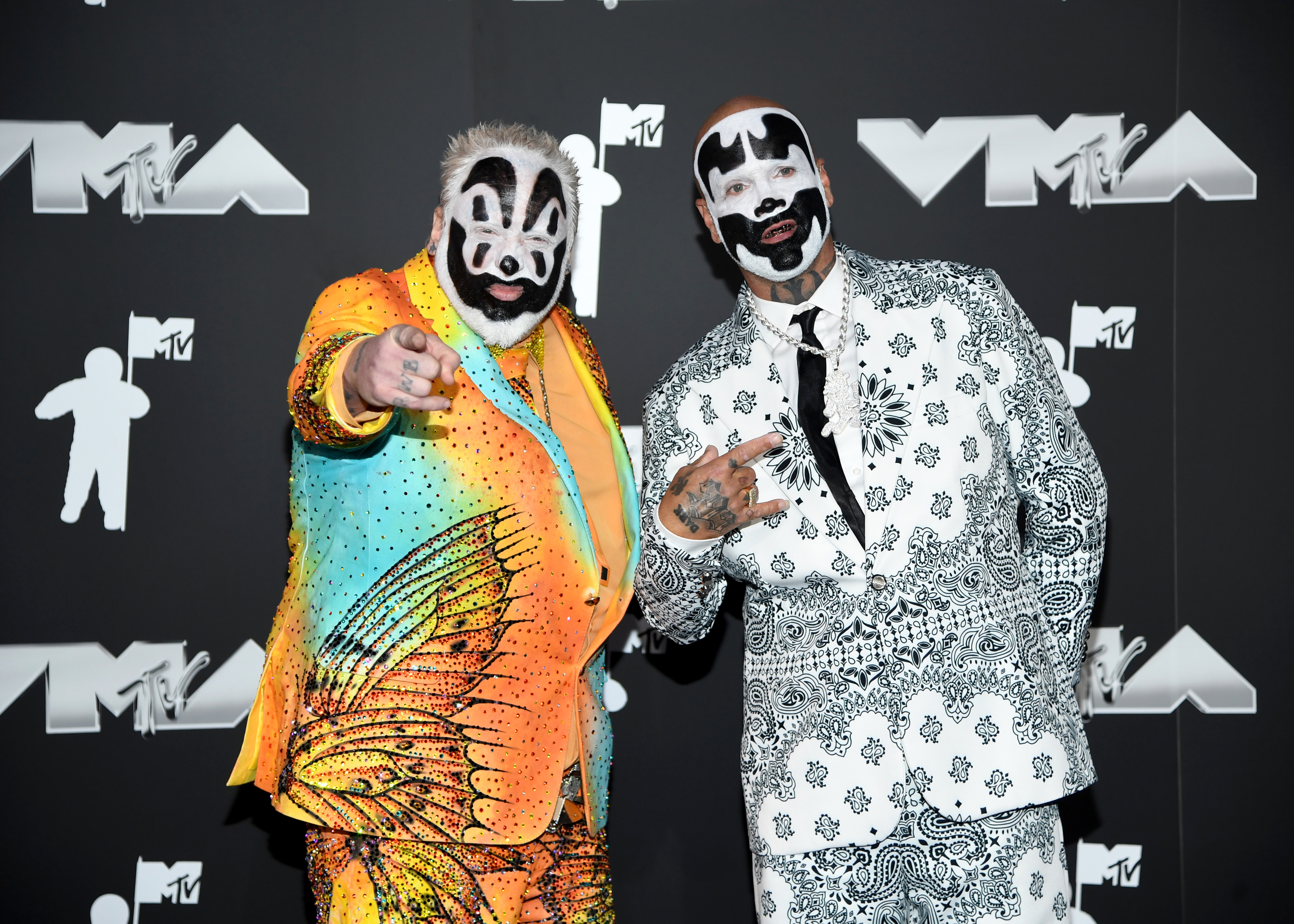 Violent J and Shaggy 2 Dope from Insane Clown Posse on the MTV VMA red carpet, wearing brightly patterned and monochrome suits with face paint