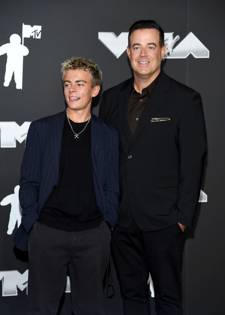 Carson Daly and Jackson Daly stand together at the MTV Video Music Awards; Carson is in a suit, and Jackson wears a shirt with a striped jacket