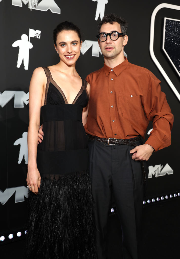 Margaret Qualley in a feathered gown and Jack Antonoff in a shirt and pants on the MTV VMAs red carpet