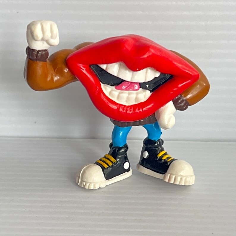 Cartoon character with large red lips, muscular arms, blue pants, and black sneakers, flexing its left arm in a powerful pose