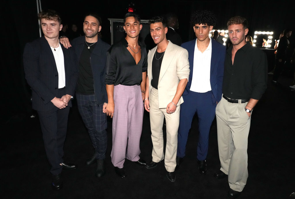 six band members dressed in modern, stylish attire