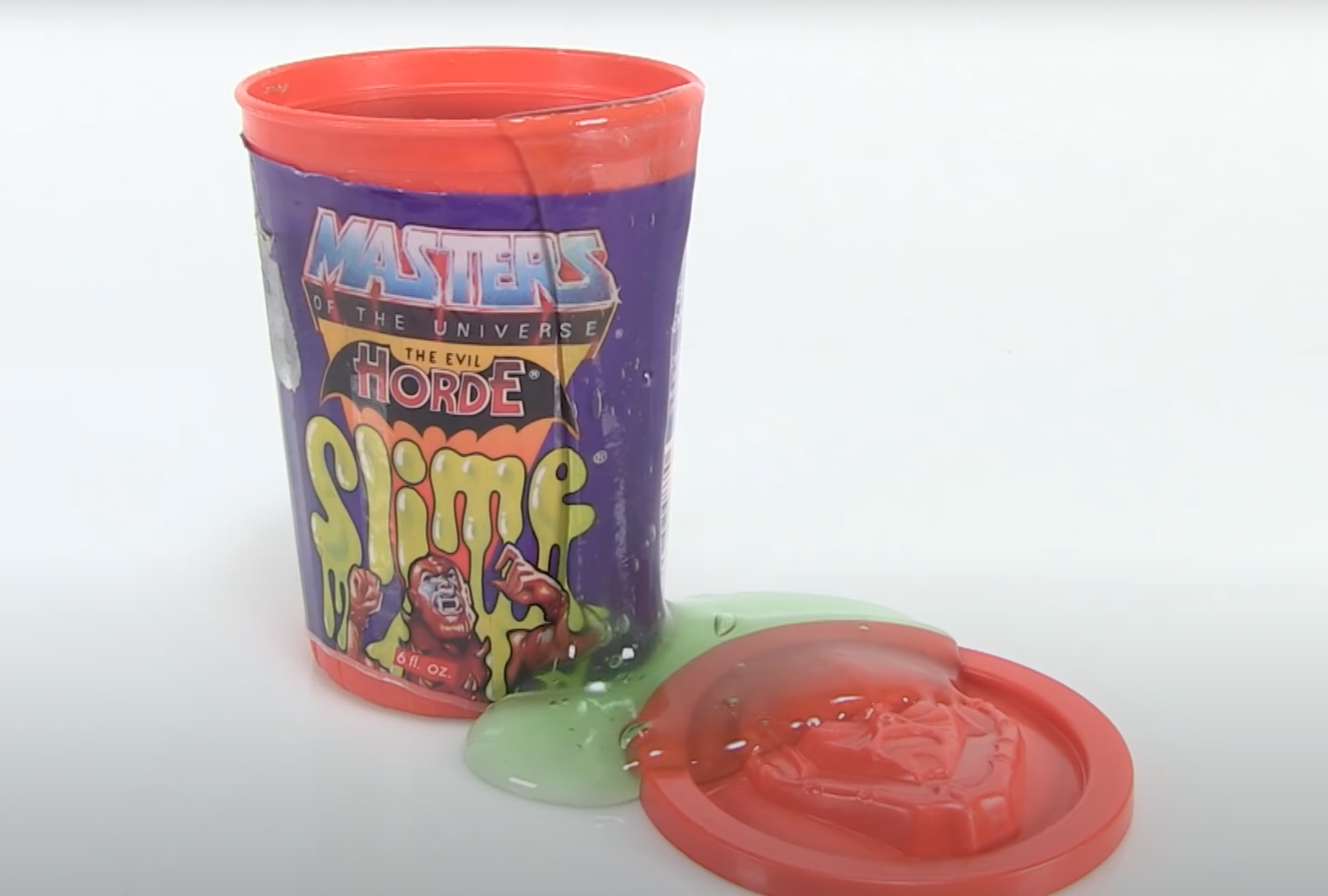 He-Man Masters of the Universe Evil Horde slime container with slime oozing out, lid placed on the side