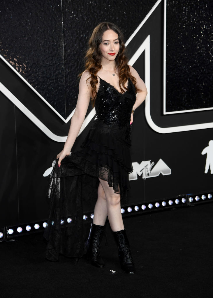 Sasha in asymmetrical, sequined dress and boots