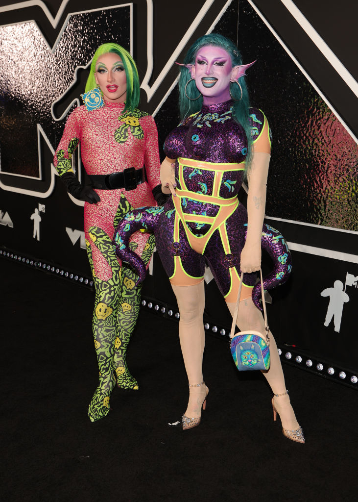 Plasma and Salina EsTitties stand on the red carpet in colorful, eccentric outfits