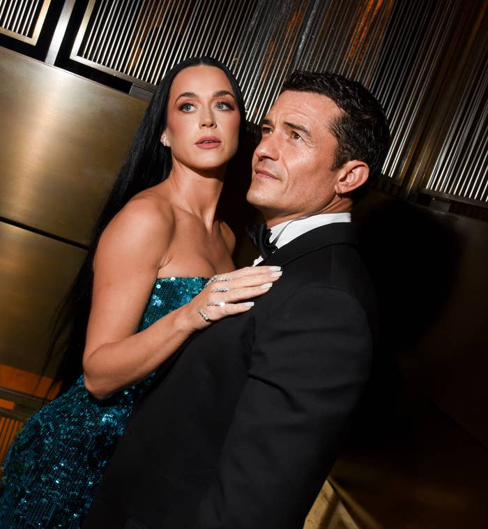 Katy Perry in a strapless gown and Orlando Bloom in a tuxedo pose together at an event