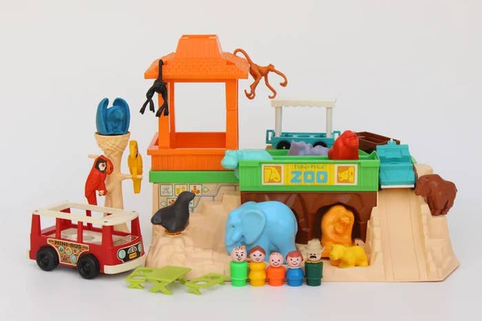 Vintage Fisher-Price playset with a zoo theme, featuring a zookeeper and various animal figures, including a lion, elephant, and monkeys