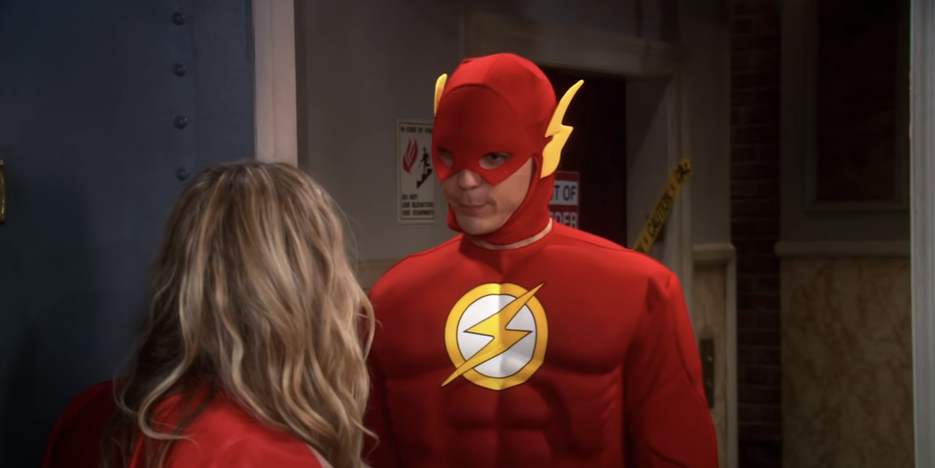 Sheldon Cooper, dressed as The Flash, stands facing Penny in a scene from &quot;The Big Bang Theory.&quot;