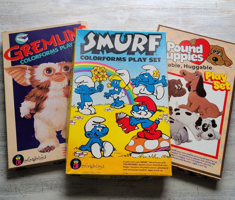 Vintage toy play sets: Gremlins, Smurf, and Pound Puppies. Colorforms play sets feature characters from each respective series in action