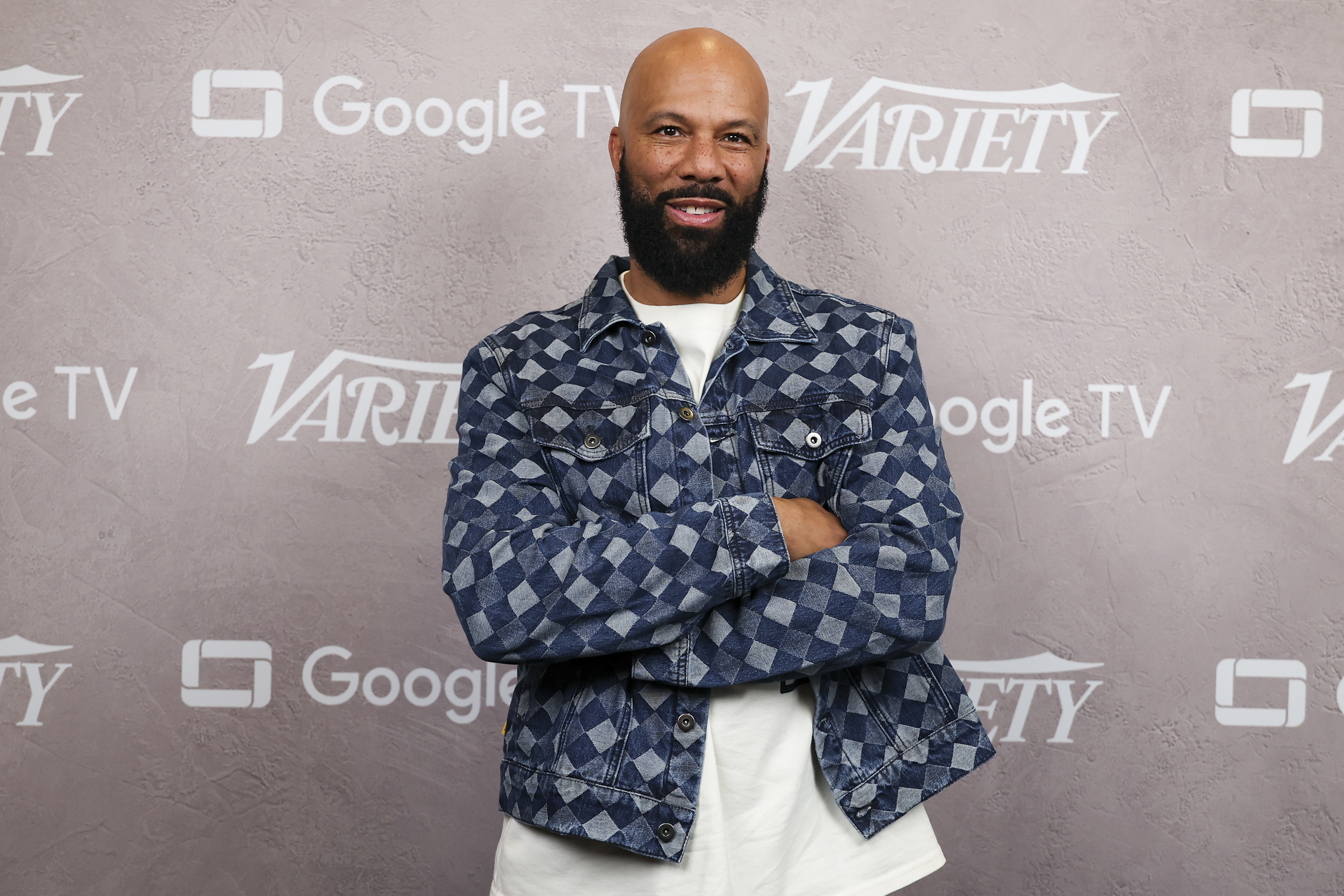 Common in a patterned denim jacket, smiles with arms crossed at a Variety event sponsored by Google TV