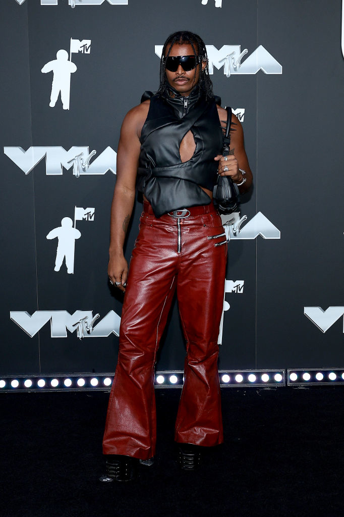 Joe at the MTV VMAs wearing a sleeveless top and leather pants, holding a small purse, and sporting sunglasses