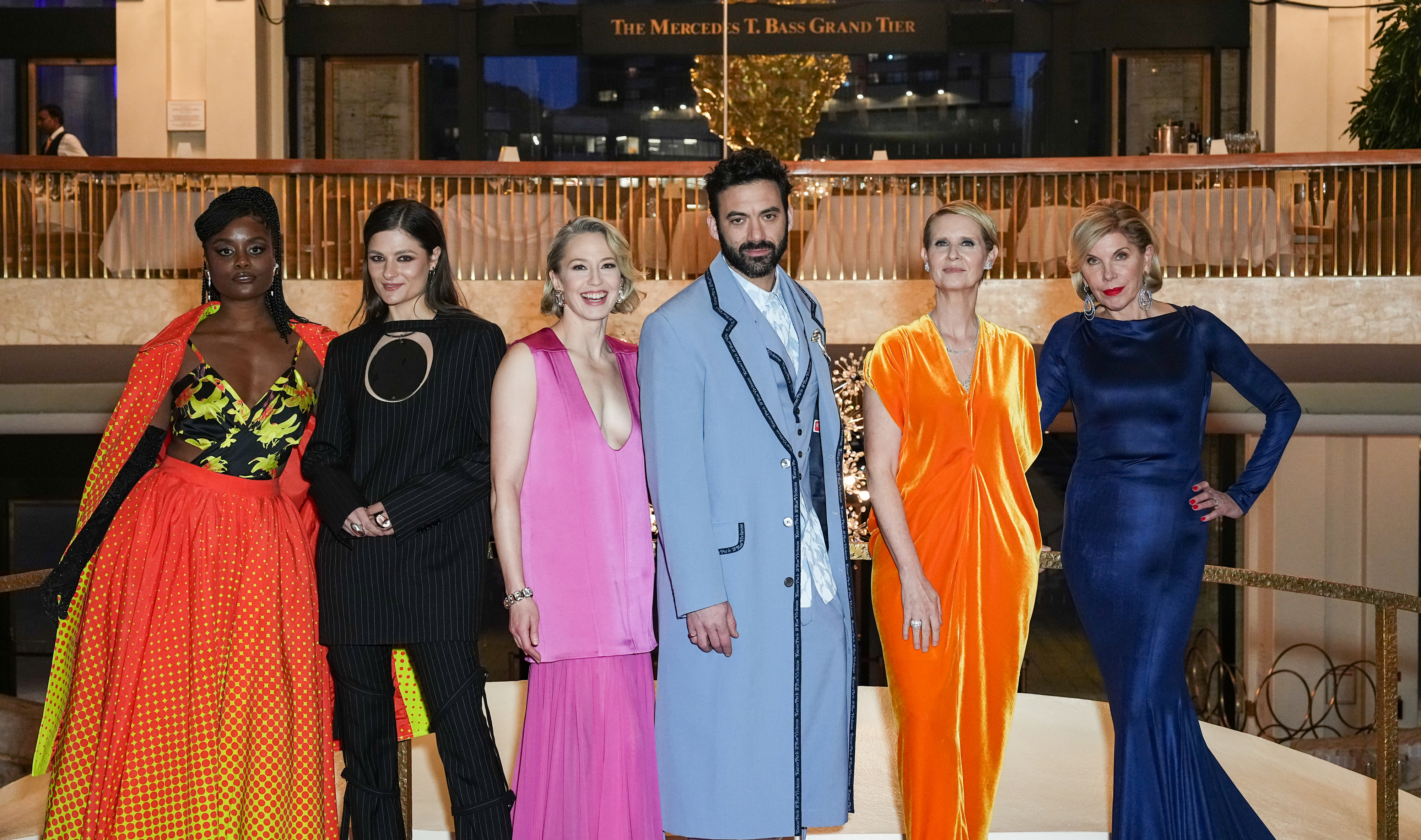 Six people pose together in formal attire at an event