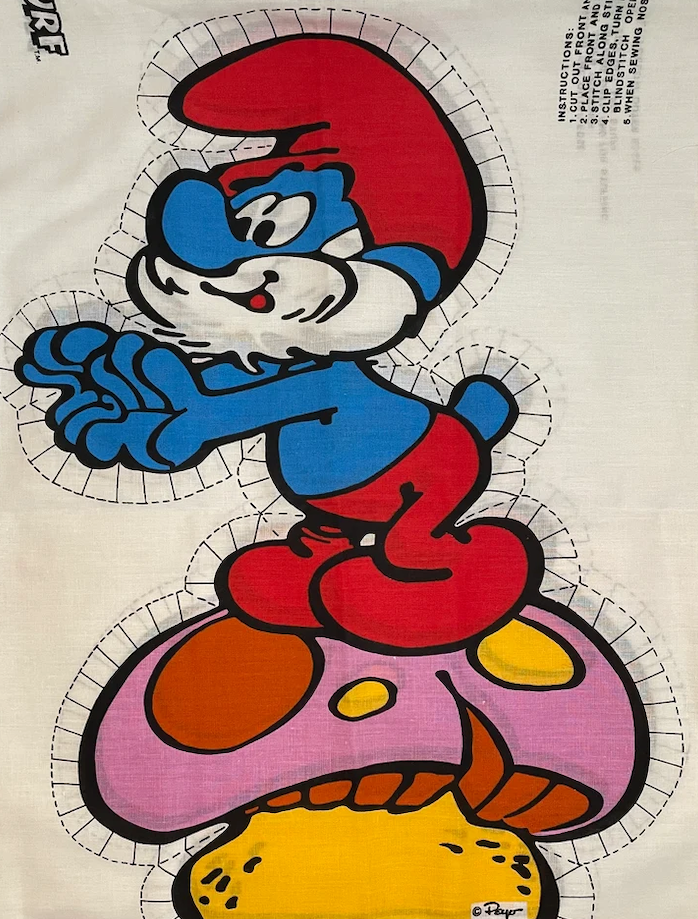 Papa Smurf cartoon character standing on a large mushroom