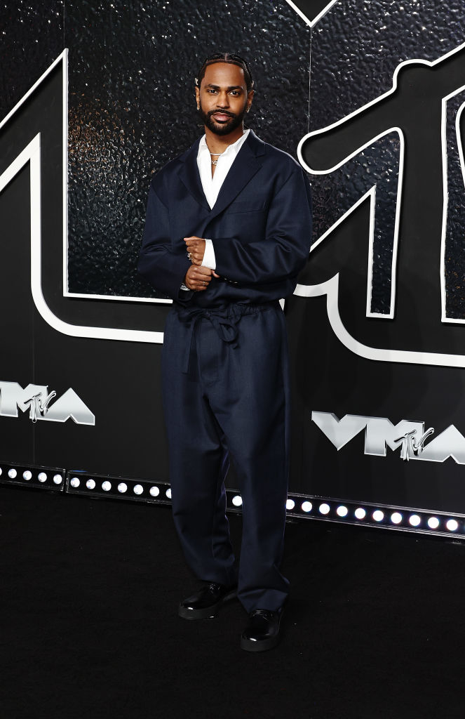 Big Sean wearing a stylish dark suit that ties at the waist poses at the MTV Video Music Awards