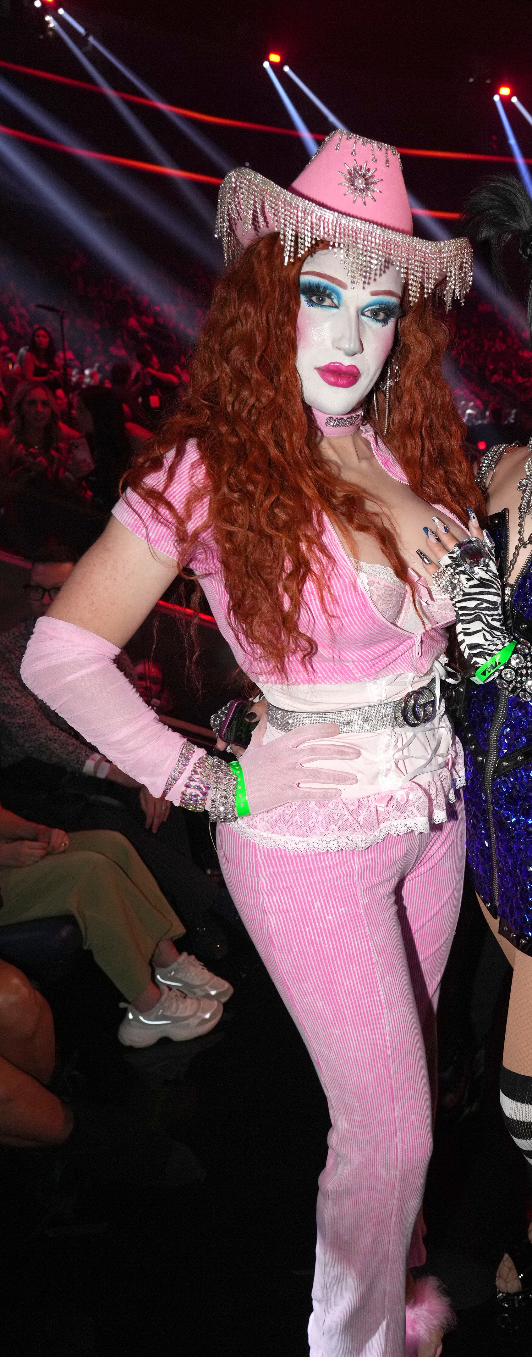 Plane Jane in velour pants and low cut top with silver belt and silver-fringed cowboy hat