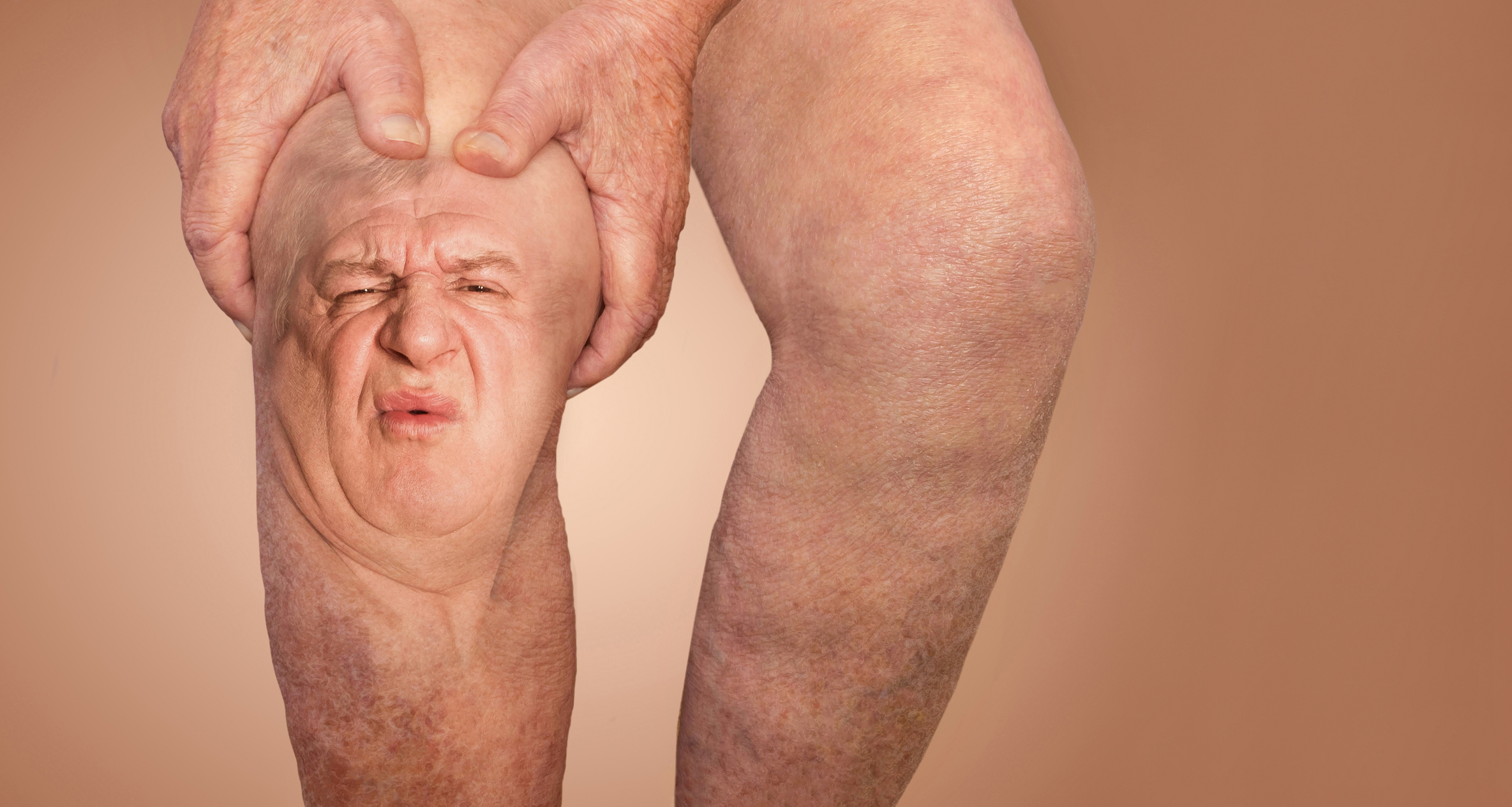 A person’s legs with an older man's face superimposed onto one knee, which appears to be squeezed by hands