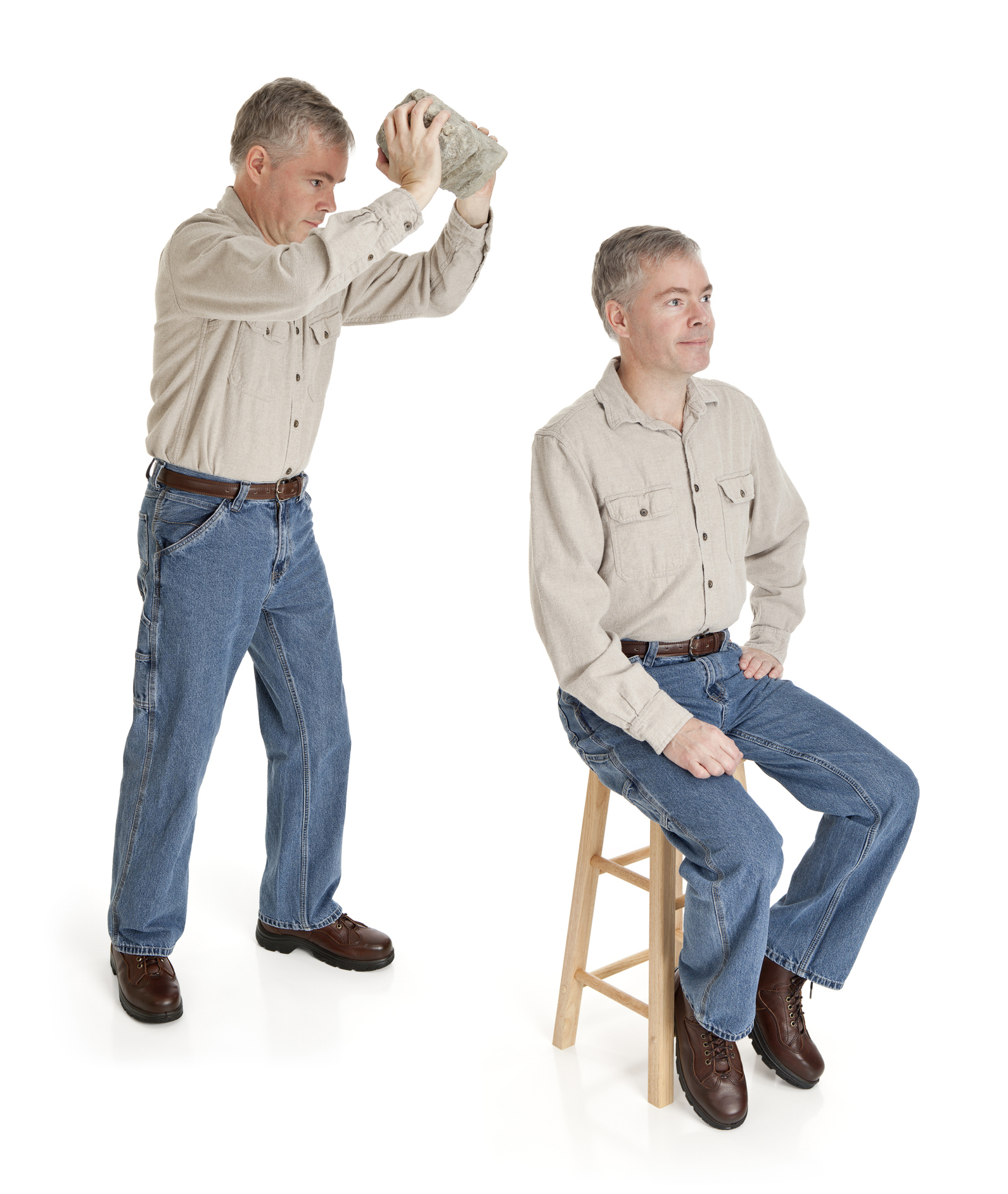 A man stands holding an object above the head of another identical man who is sitting on a stool. Both wear casual shirts, jeans, and brown shoes