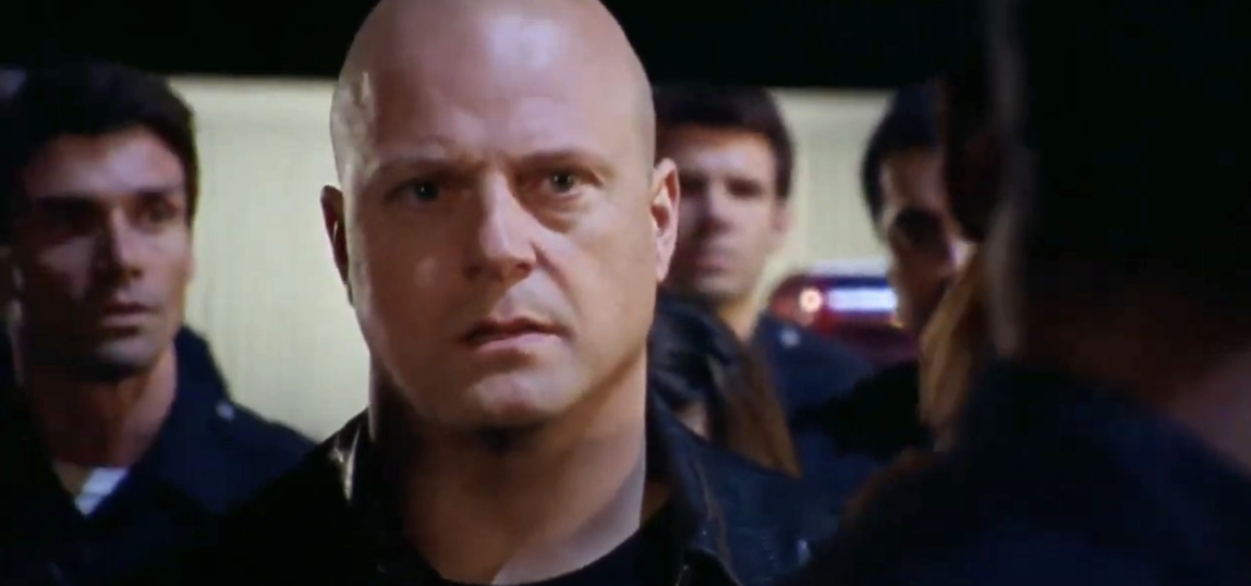 Michael Chiklis as Vic Mackey in a serious scene from &quot;The Shield,&quot; surrounded by fellow officers
