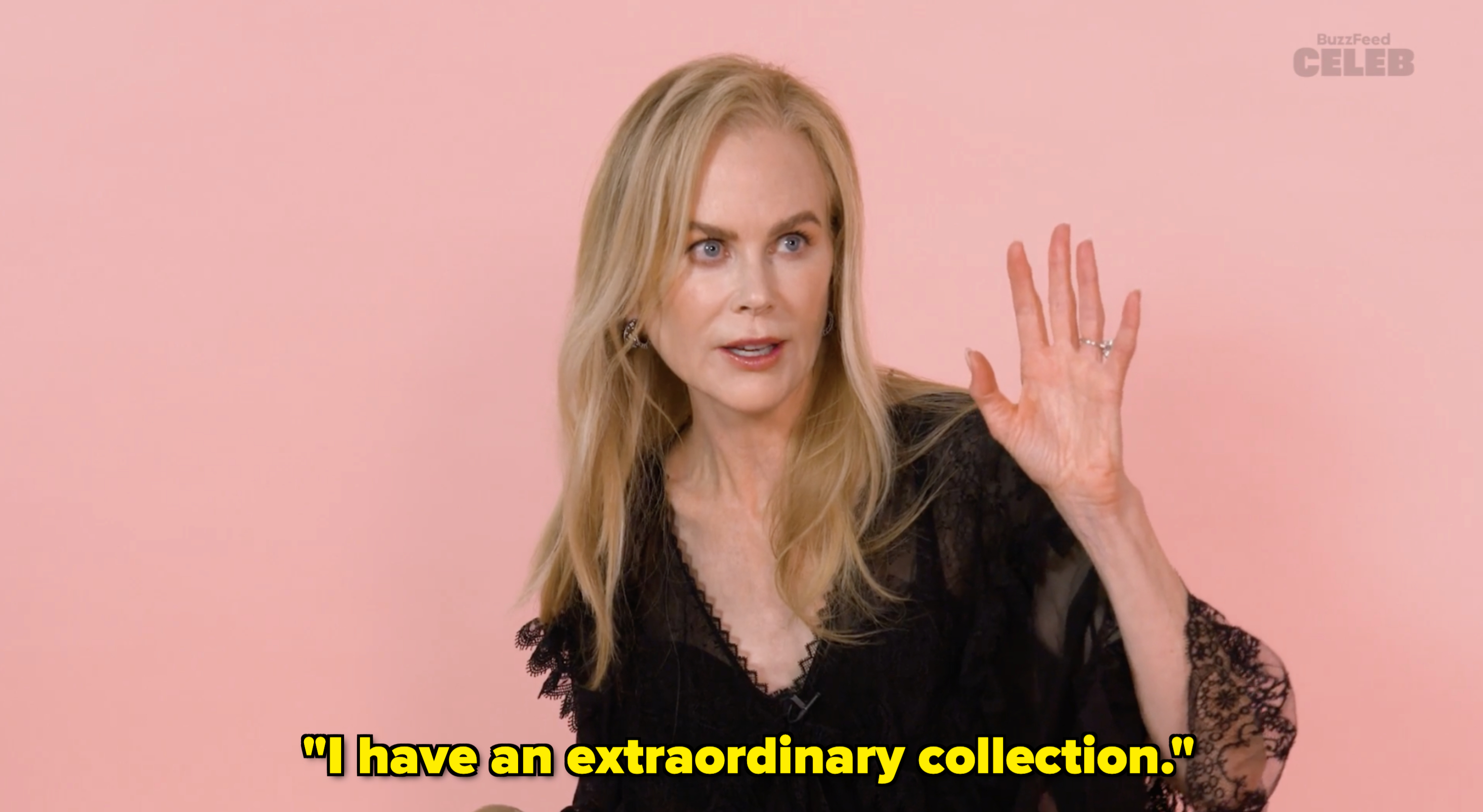 Nicole Kidman waves, wearing a lace outfit