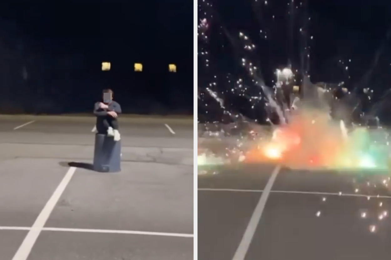 A person sits on a trash can in an empty parking lot. On the right, fireworks explode close to where they sat