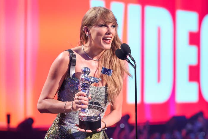 Taylor Swift holds MTV Video Music Award and speaks into microphone on stage