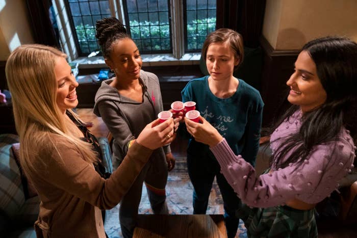 Leighton (Reneé Rapp), Whitney (Alyah Chanelle Scott), Kimberly (Pauline Chalamet), and Bela (Amrit Kaur) toasting with drinks in a dorm room setting