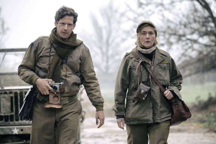 Andy Samberg and Kate Winslet dressed walking outdoors in a scene from "Lee"