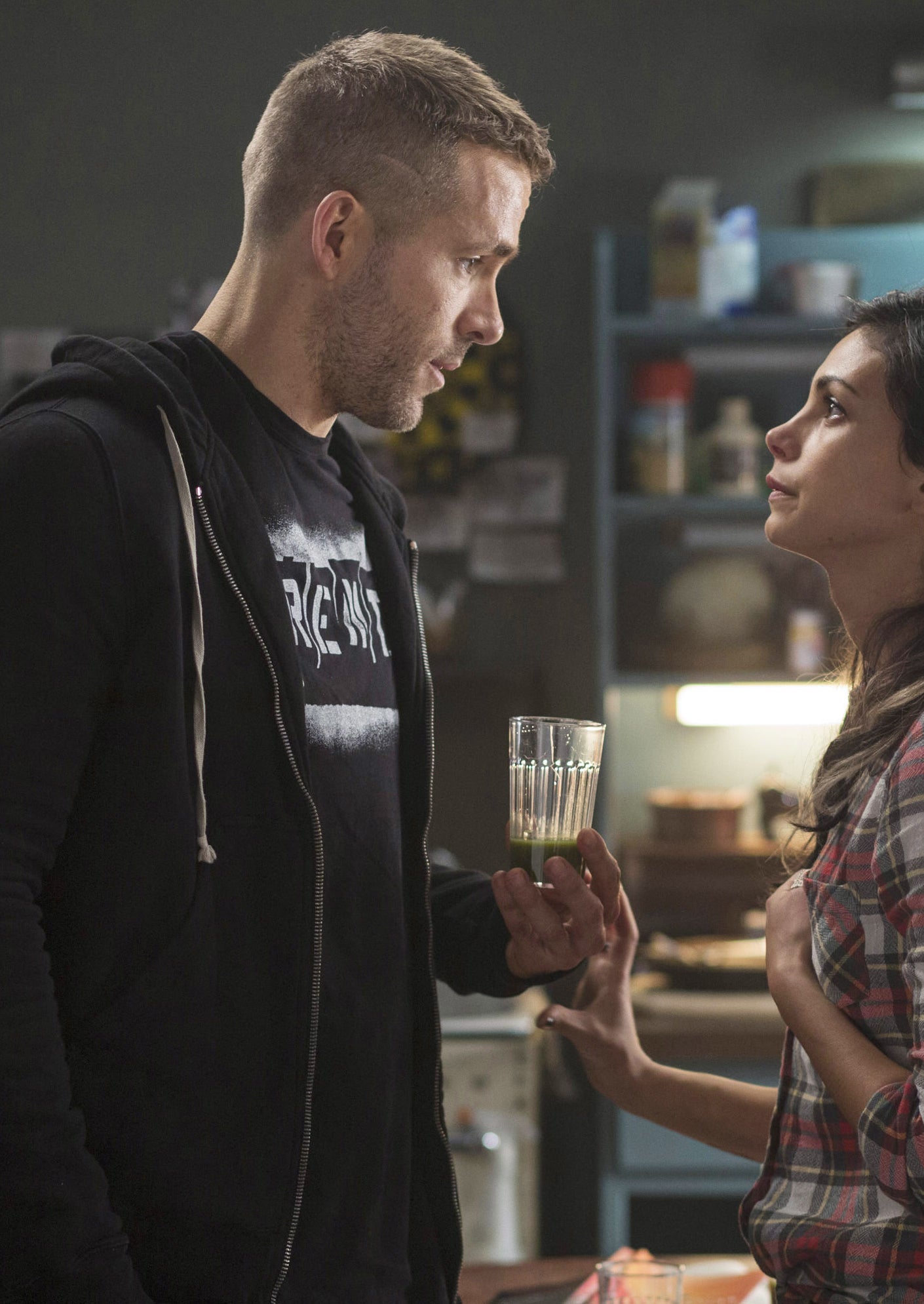 Ryan Reynolds holding a glass of smoothie in a kitchen scene