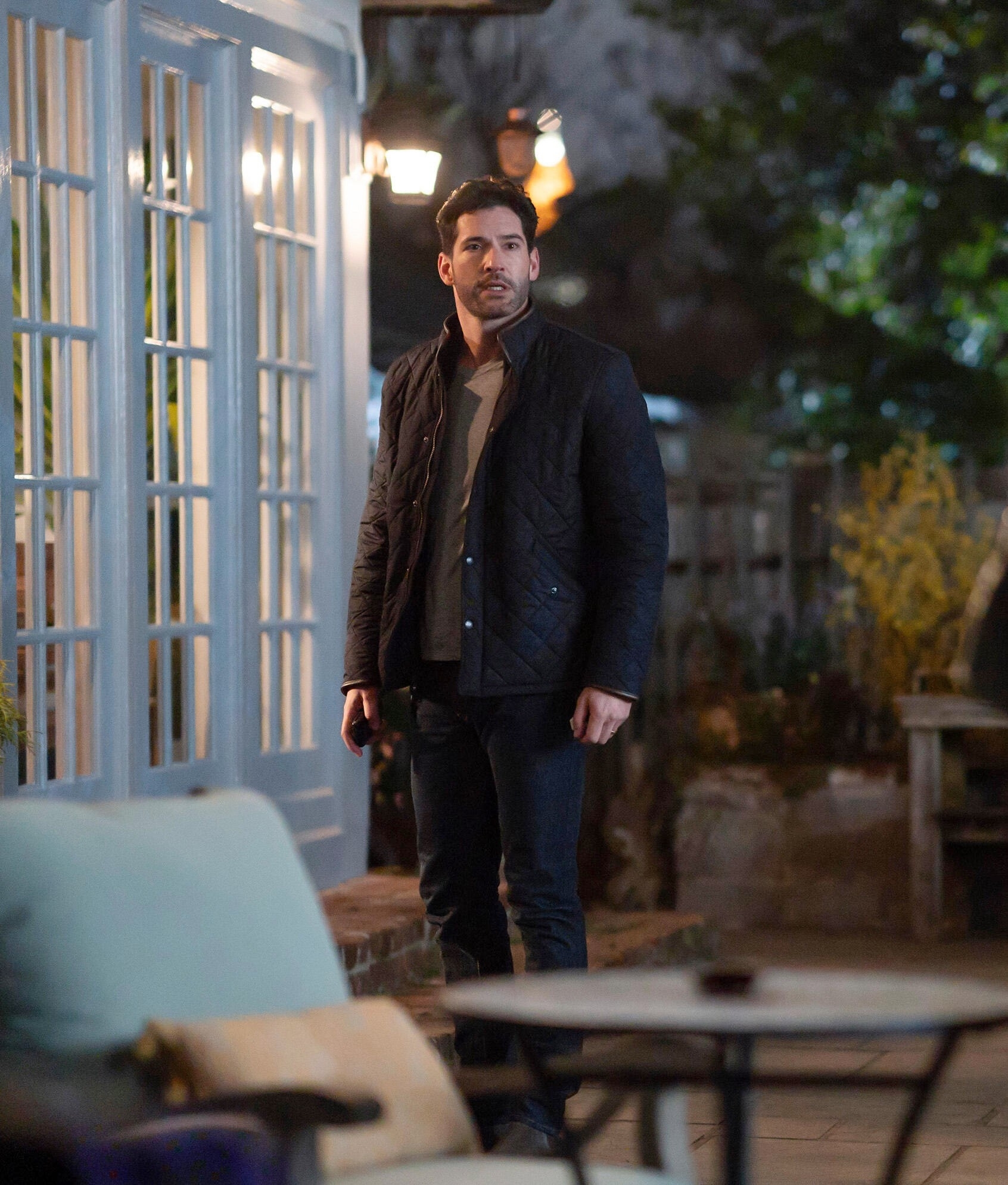 Tom Ellis standing outdoors in casual clothing in "Tell Me Lies"