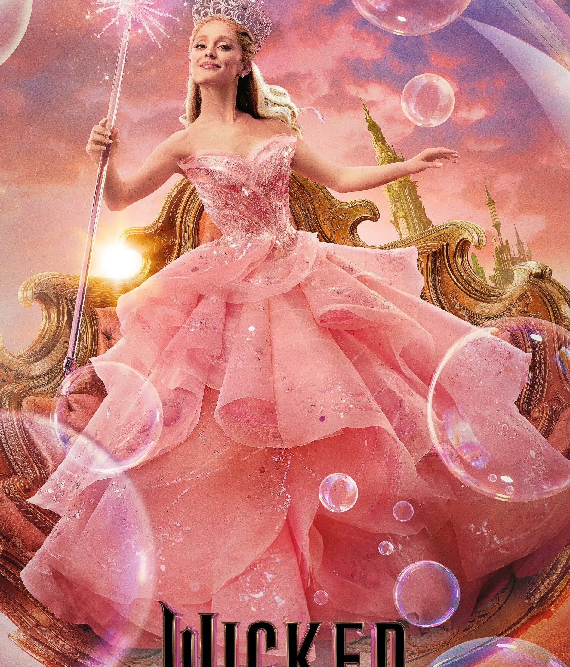 Ariana Grande, as Glinda from "Wicked," is wearing a layered, flowing gown and holding a star-topped wand while floating in a bubble