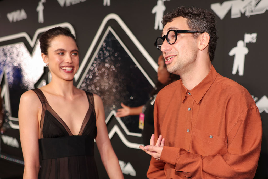 Margaret Qualley in a stylish dress smiles at Jack Antonoff in a casual button-up shirt at the MTV Video Music Awards
