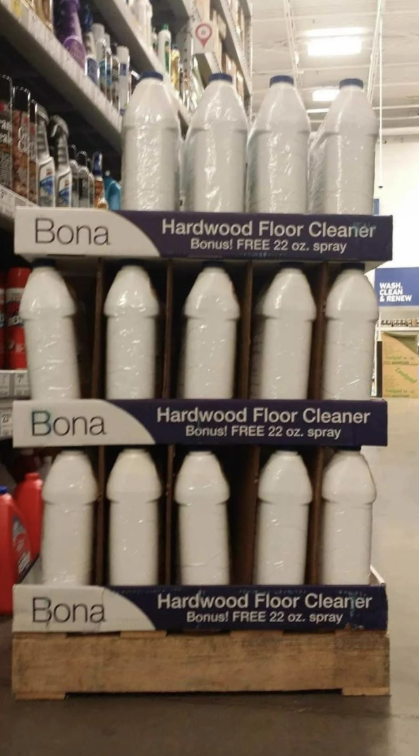 Display of Bona Hardwood Floor Cleaner, showcasing multiple 22 oz spray bottles stacked on a store shelf