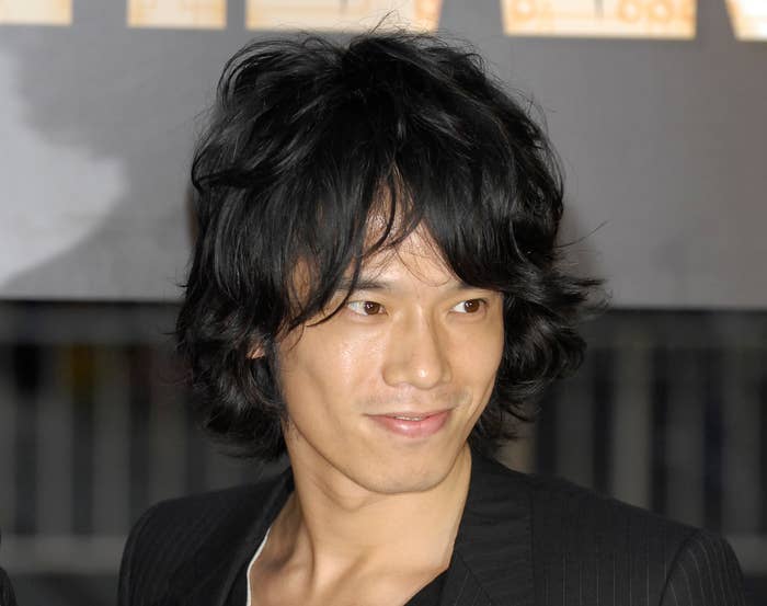 男性がスーツを着て微笑んでいます。