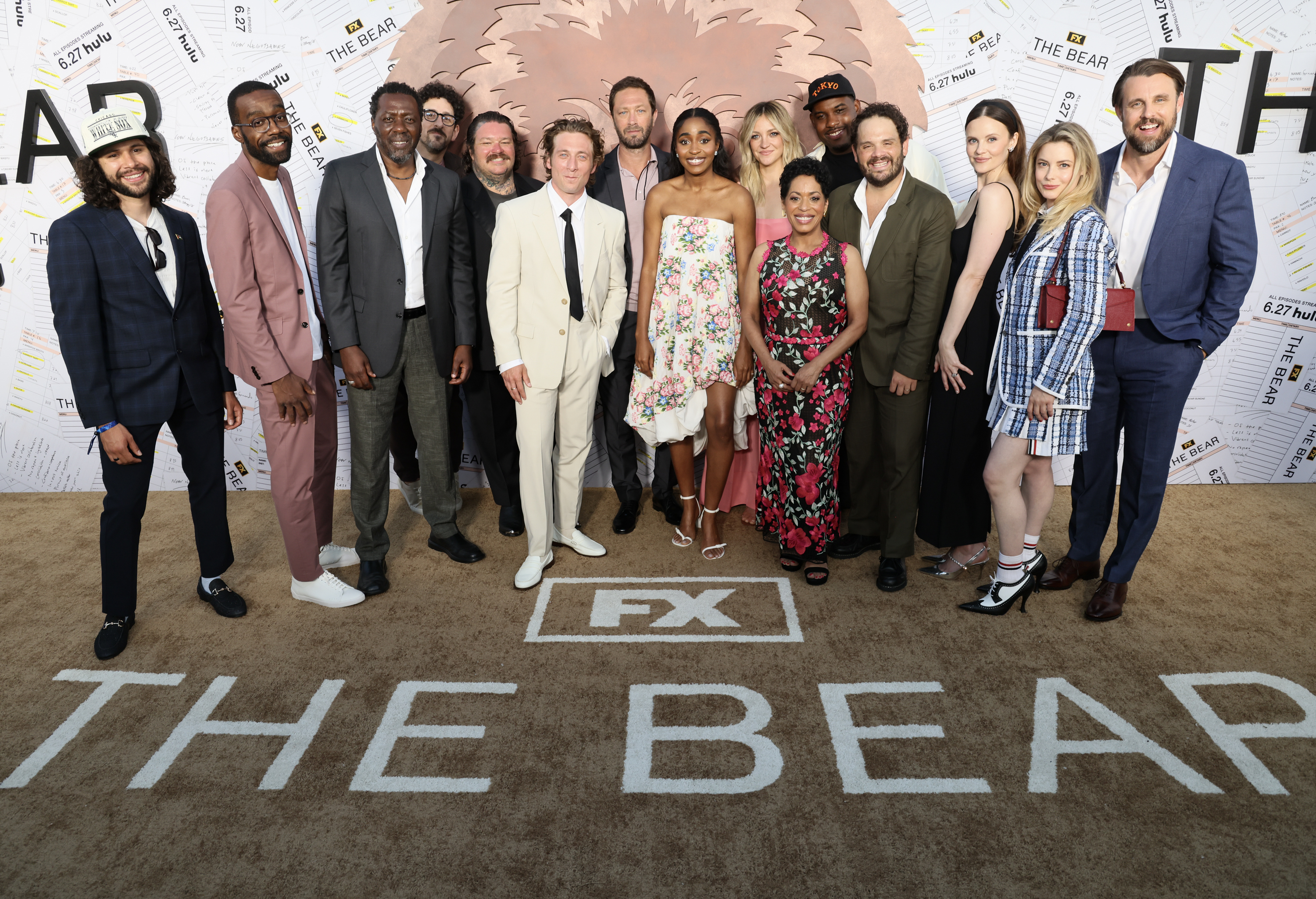 The cast of "The Bear" on the red carpet. They are standing in front of a backdrop with the show's name