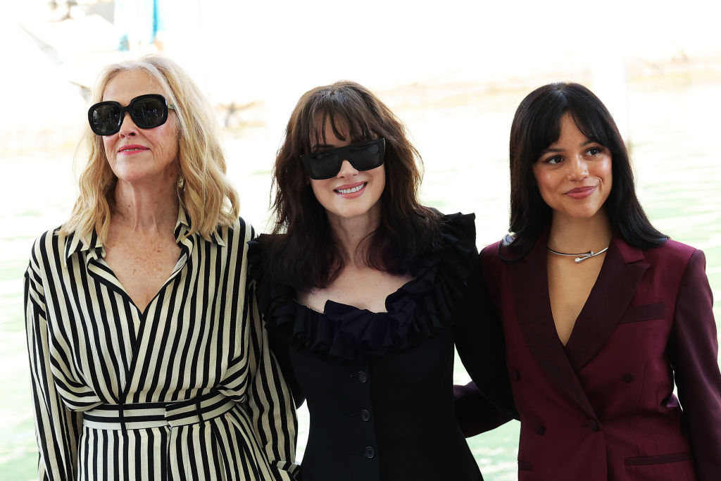 Diane Keaton, Winona Ryder, and Jenna Ortega stand together outdoors, smiling and wearing fashionable outfits
