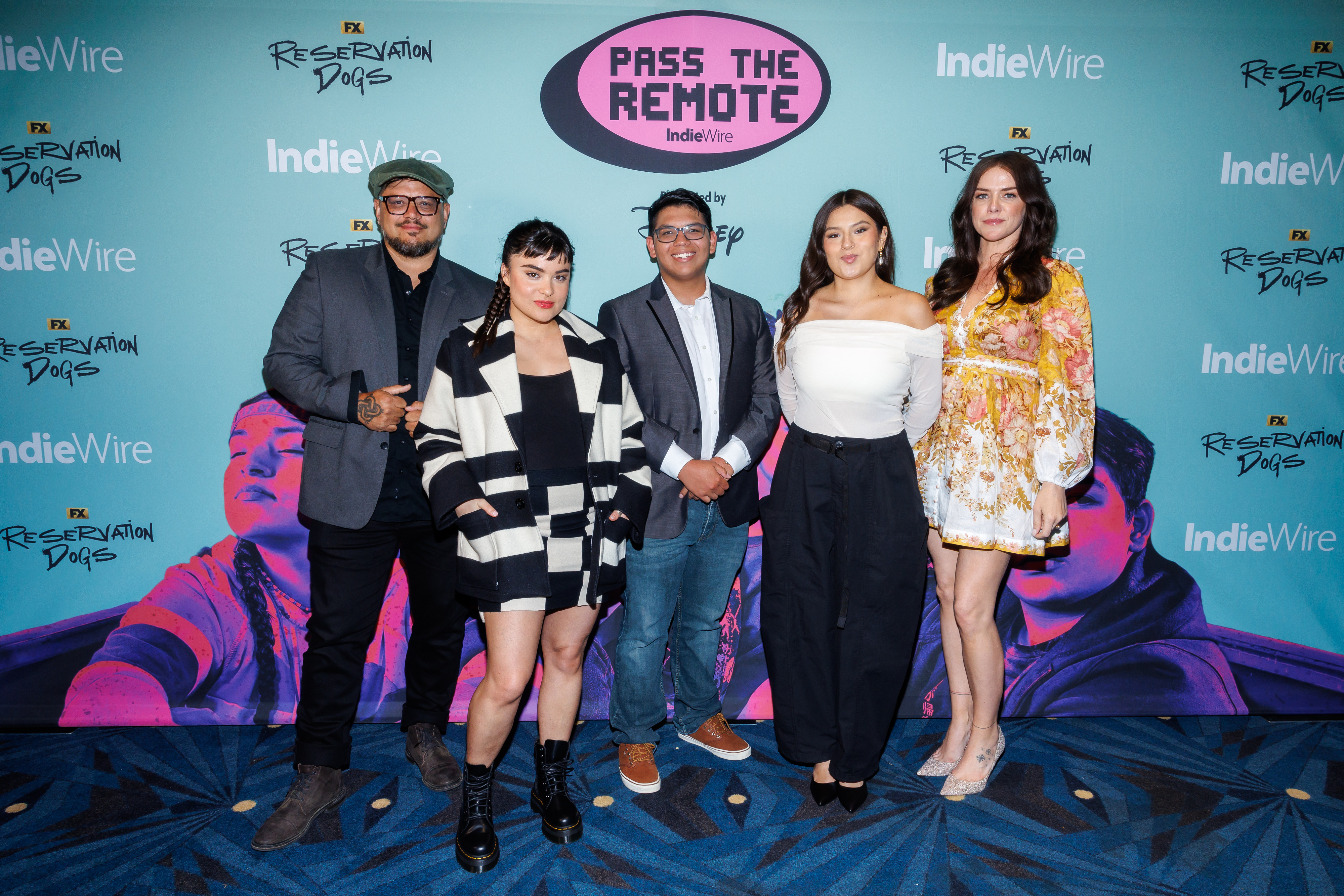 Five people pose on a red carpet at the "Pass the Remote" event by IndieWire