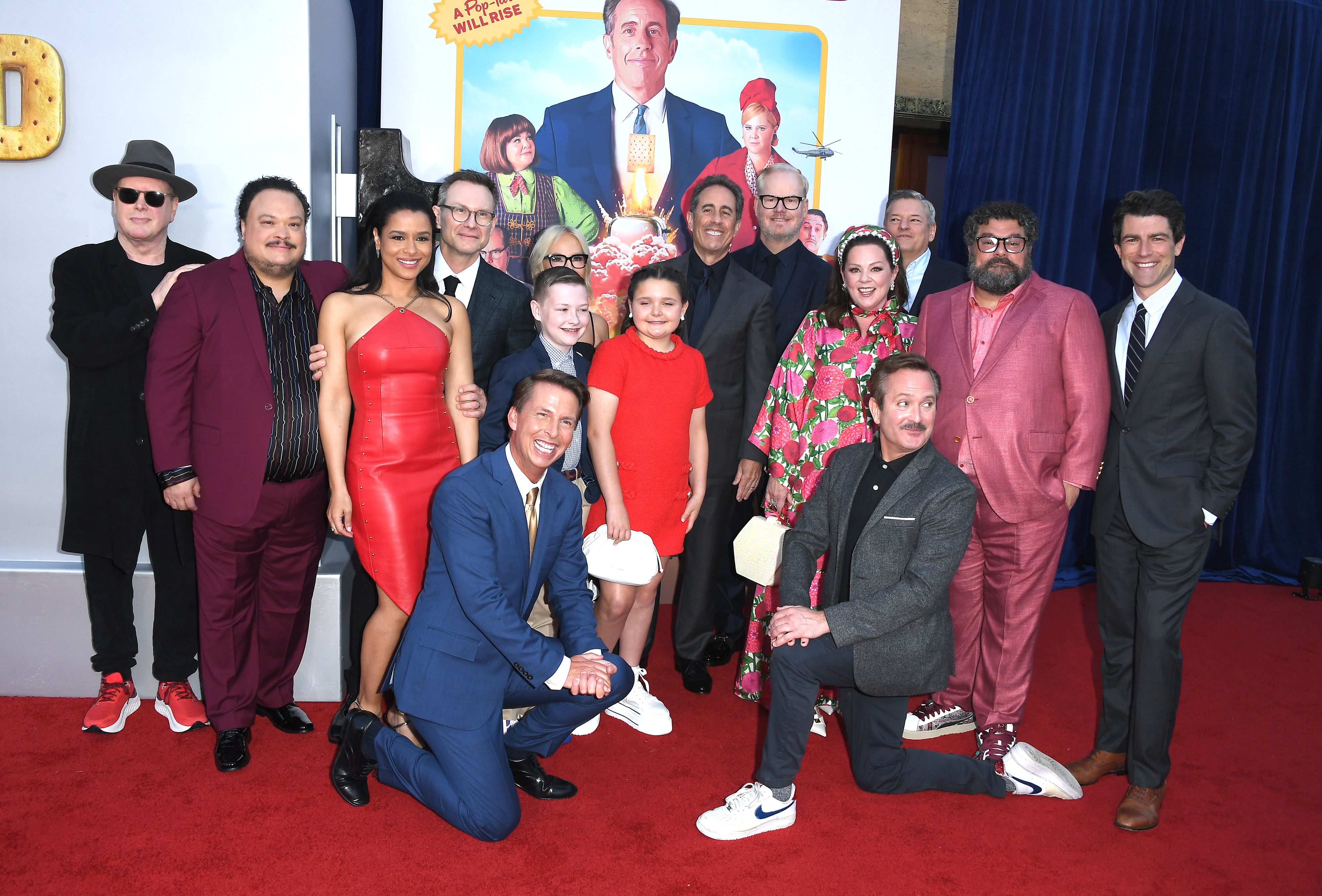 Group pose on the red carpet in stylish attire at a movie premiere