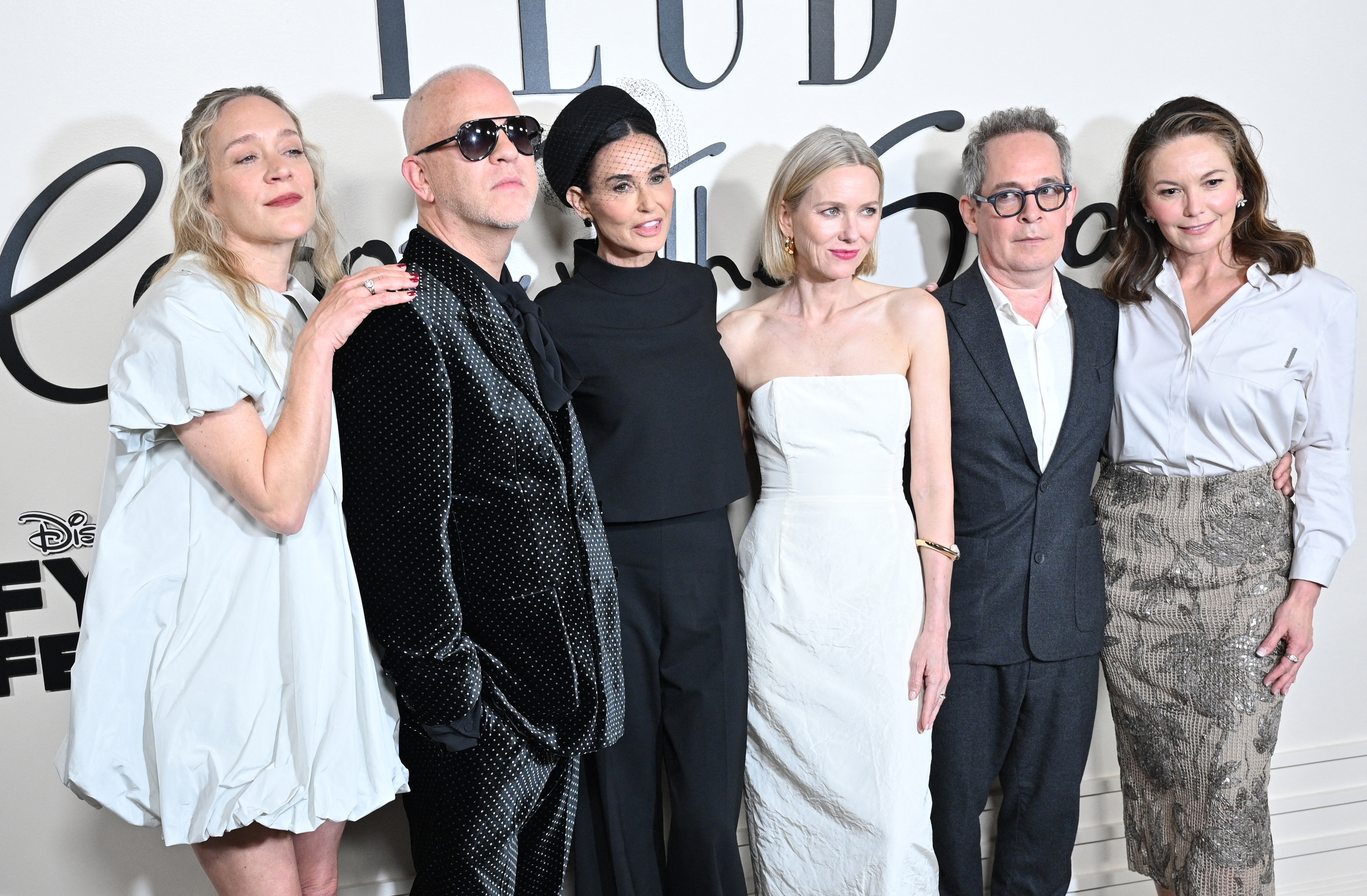 Six people pose together at an event