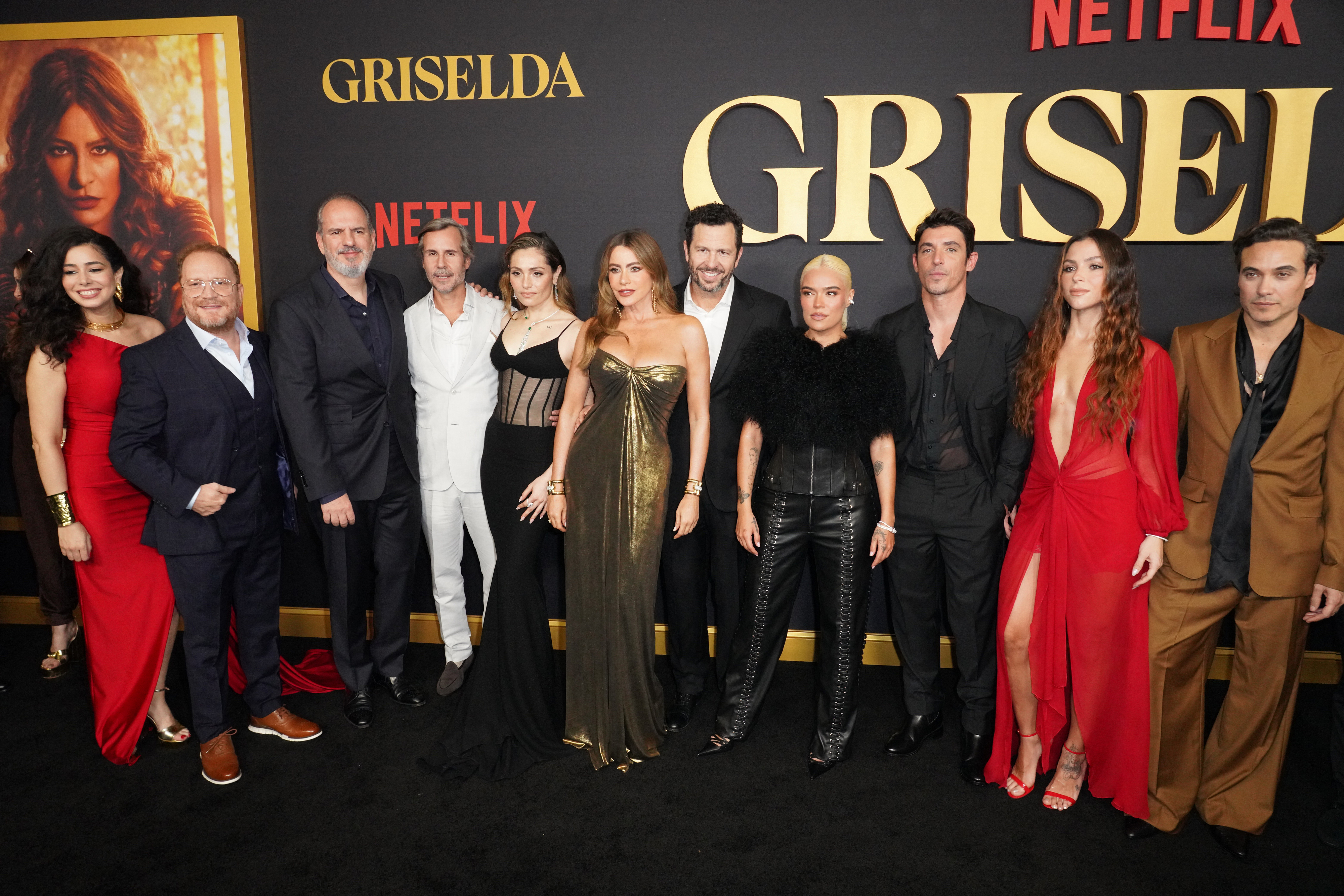 Griselda cast and crew, including Sofia Vergara, pose in formal attire at a Netflix event in front of a backdrop featuring the show's title.