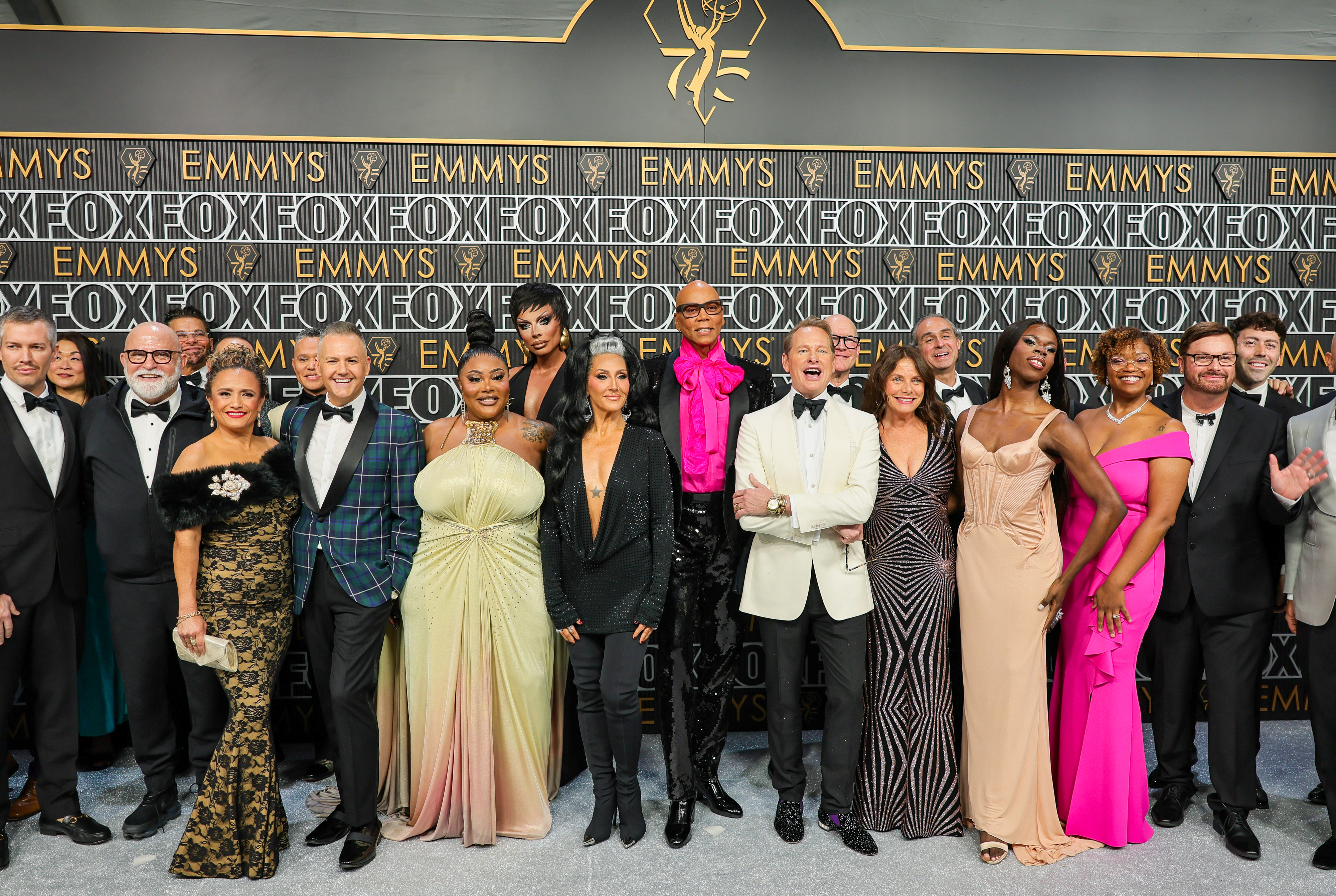 Group of people posing on the red carpet in formal attire at the Emmys