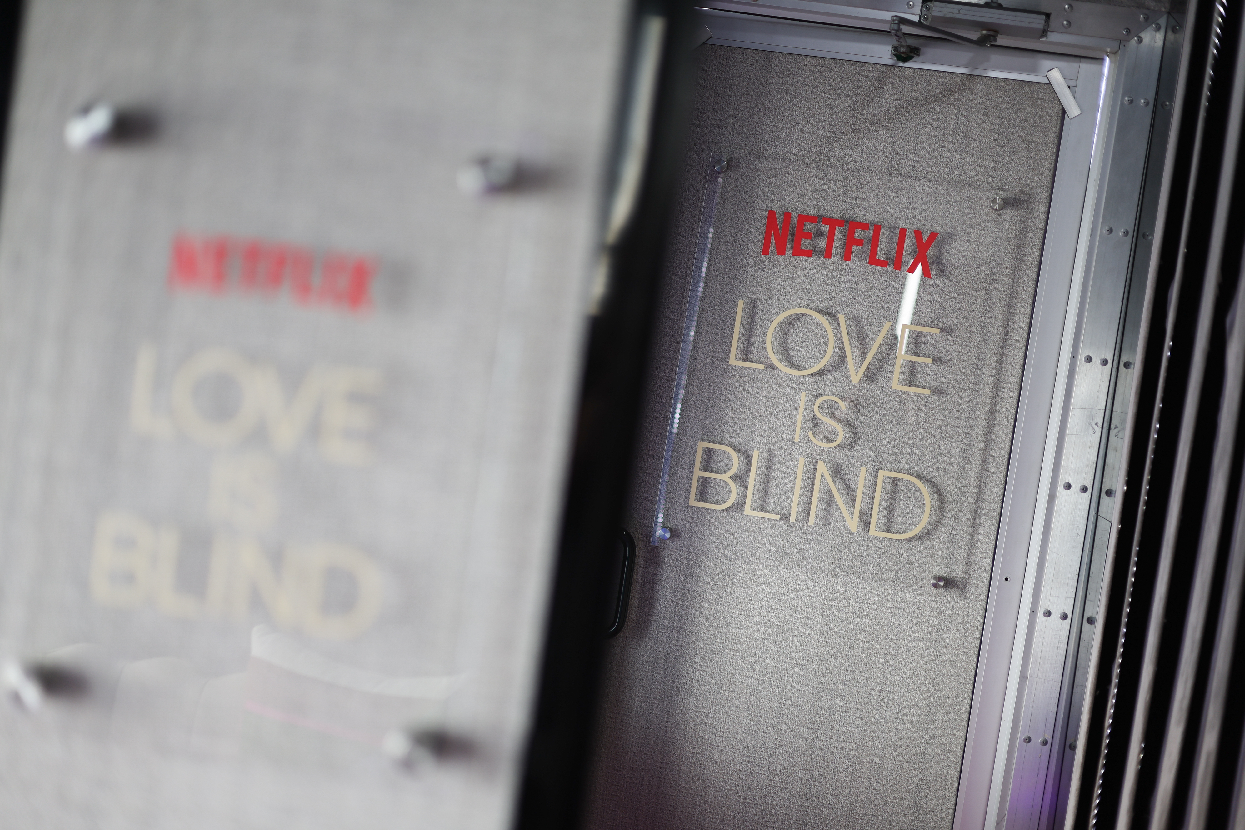Sign reads "Netflix Love is Blind" in a dimly lit setting, emphasizing the show's title prominently