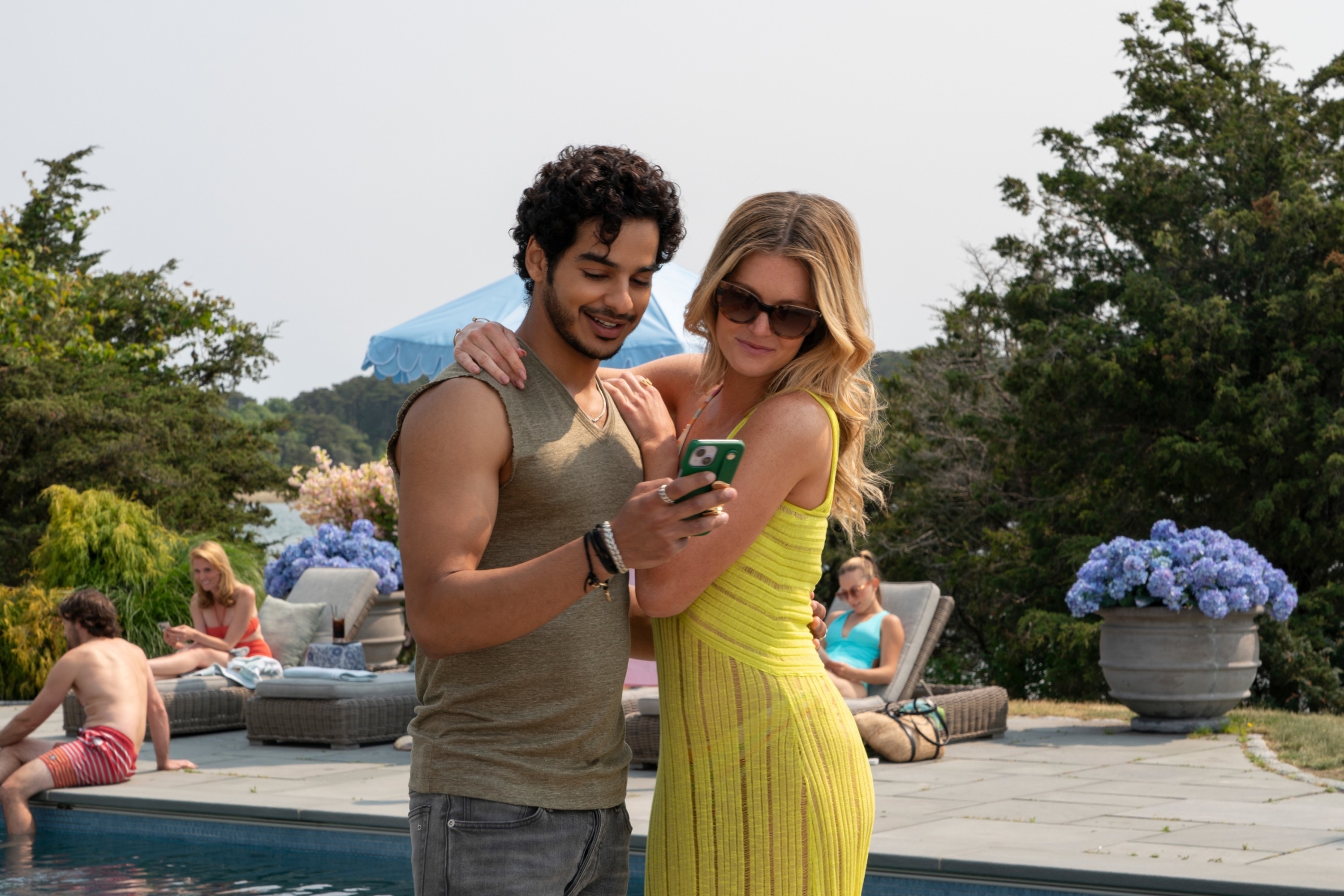 Ishaan Khattar and Meghann Fahy looking at a phone in "The Perfect Couple"